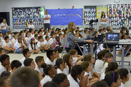 Classroom watches ass ARISS worker uses computer